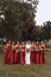 A group of bridesmaids wearing mix and match burnt orange bridesmaid dresses