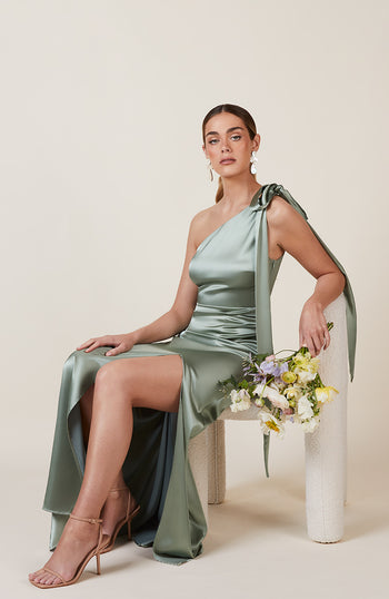 Satin one shoulder bridesmaids dress in sage green with a detachable bow. A beautiful rich mint marine green this dress is a modern and stylish option for all occasions.