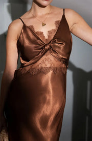 Brown satin slip dress with lace details on a neutral background