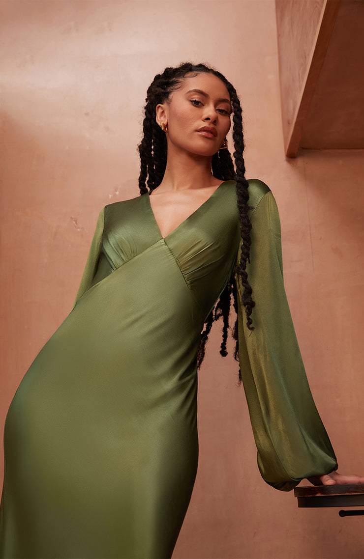Woman wearing a Rewritten long green dress with long sleeves