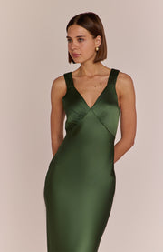 Woman wearing a green dress against a beige background
