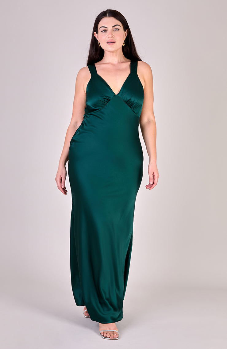 Woman wearing a green evening gown on a plain background