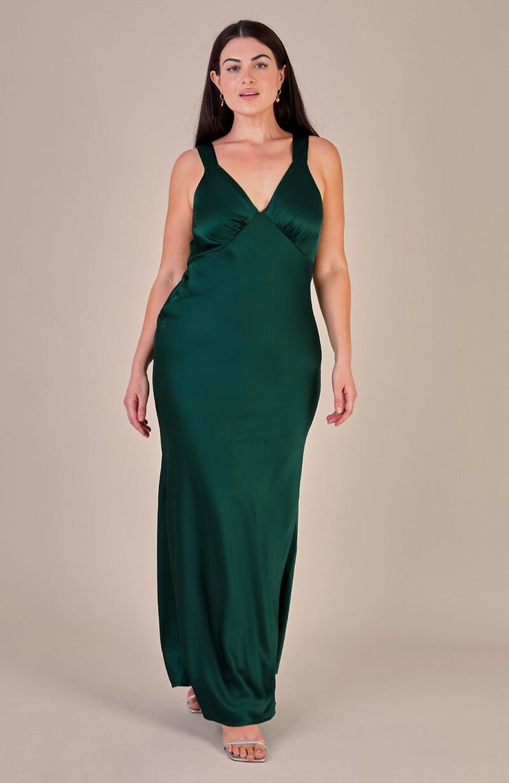 Woman wearing a green evening gown against a beige background