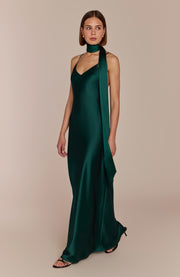 Woman wearing a green evening gown against a beige background