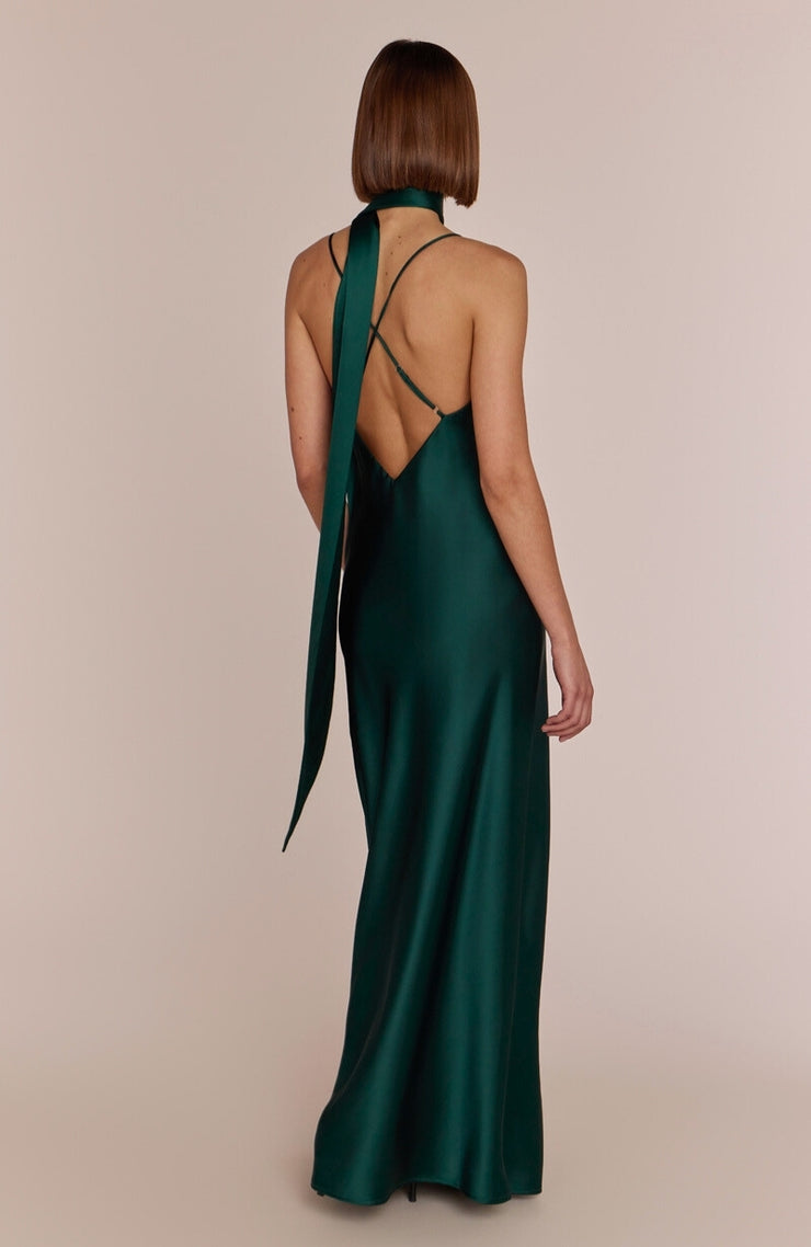 Green evening gown with open back on a beige background