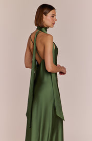 Woman wearing a green dress with a beige background