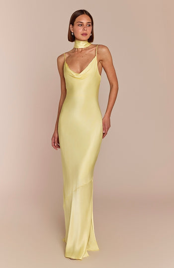 Woman wearing a light yellow evening gown against a beige background