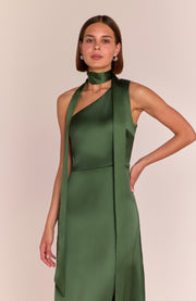 Woman wearing a green dress with a plain background