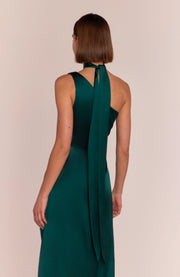 Green evening gown with a halter neckline on a beige background