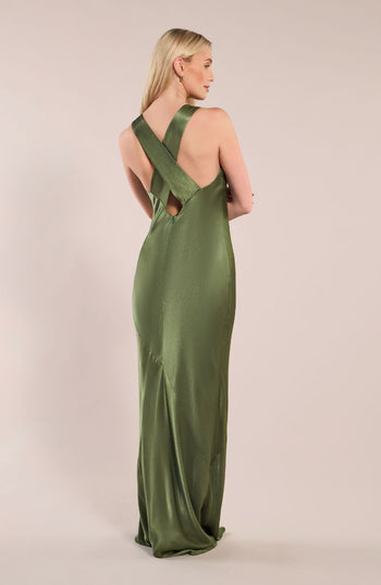Woman wearing a green evening gown with cut-out back design on a beige background