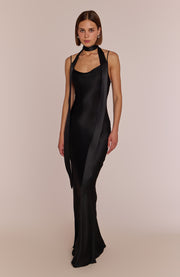 Woman wearing a black dress with sheer panels on a beige background