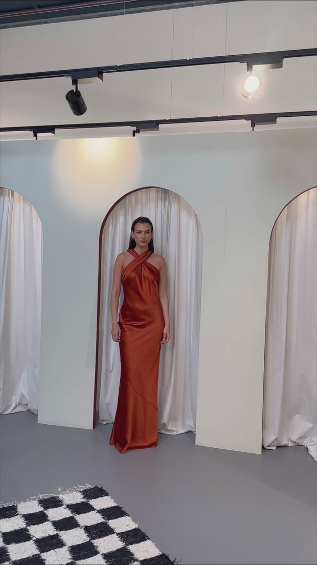 Bias cut satin cross over halterneck bridesmaids dress in burnt orange. A beautiful rich copper rust colour, this dress is a modern and stylish option for all occasions.