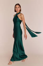 Woman wearing a green evening gown with a beige background