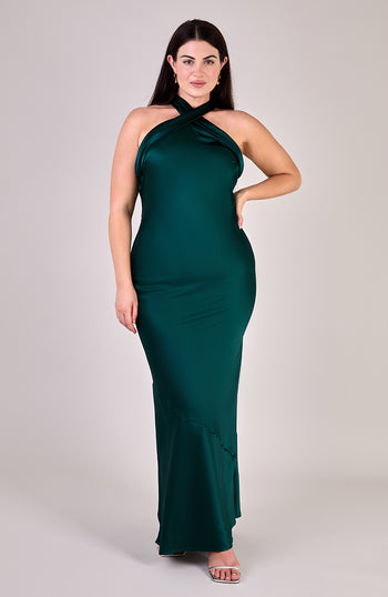 Woman wearing a green halter neck dress against a plain background