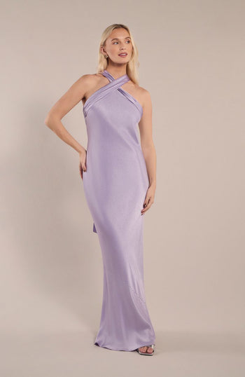 Woman wearing a lavender halterneck dress against a plain background