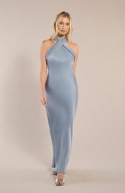 Woman wearing a light blue halter neck gown against a beige background