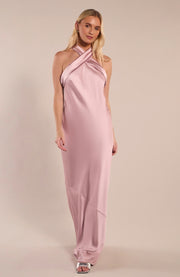 Woman wearing a pink halter neck gown on a beige background