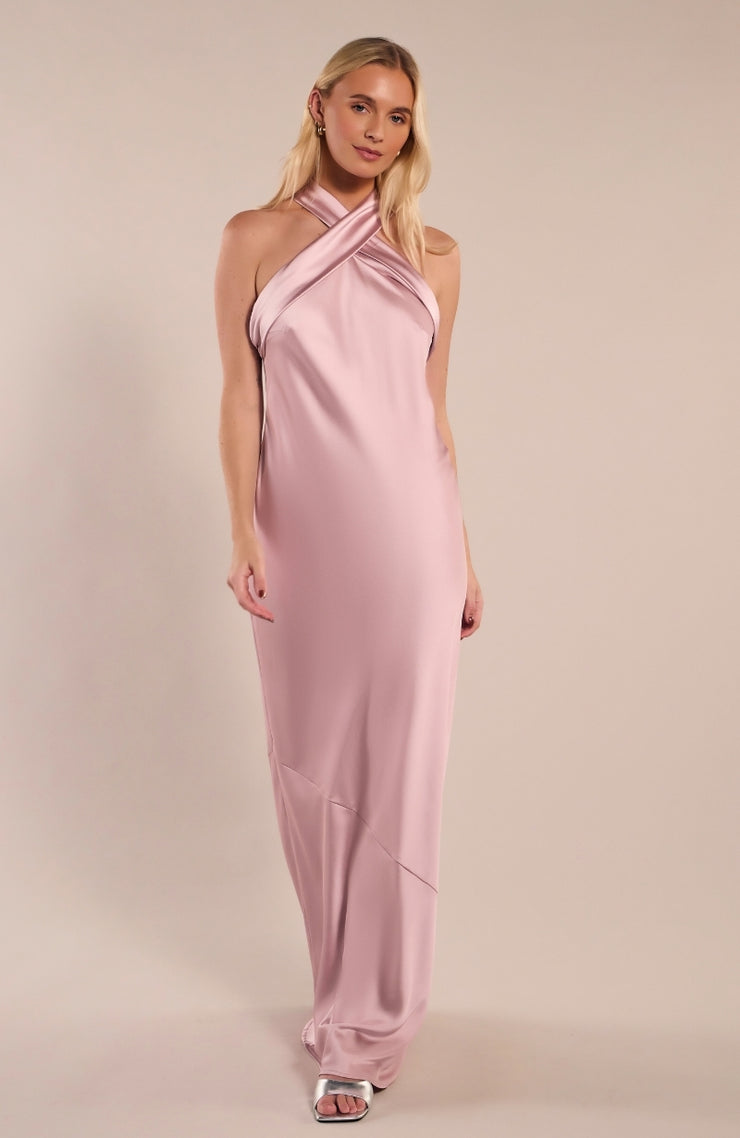 Woman wearing a pink halter neck gown on a beige background