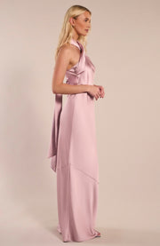 Woman wearing a pink satin gown against a beige background