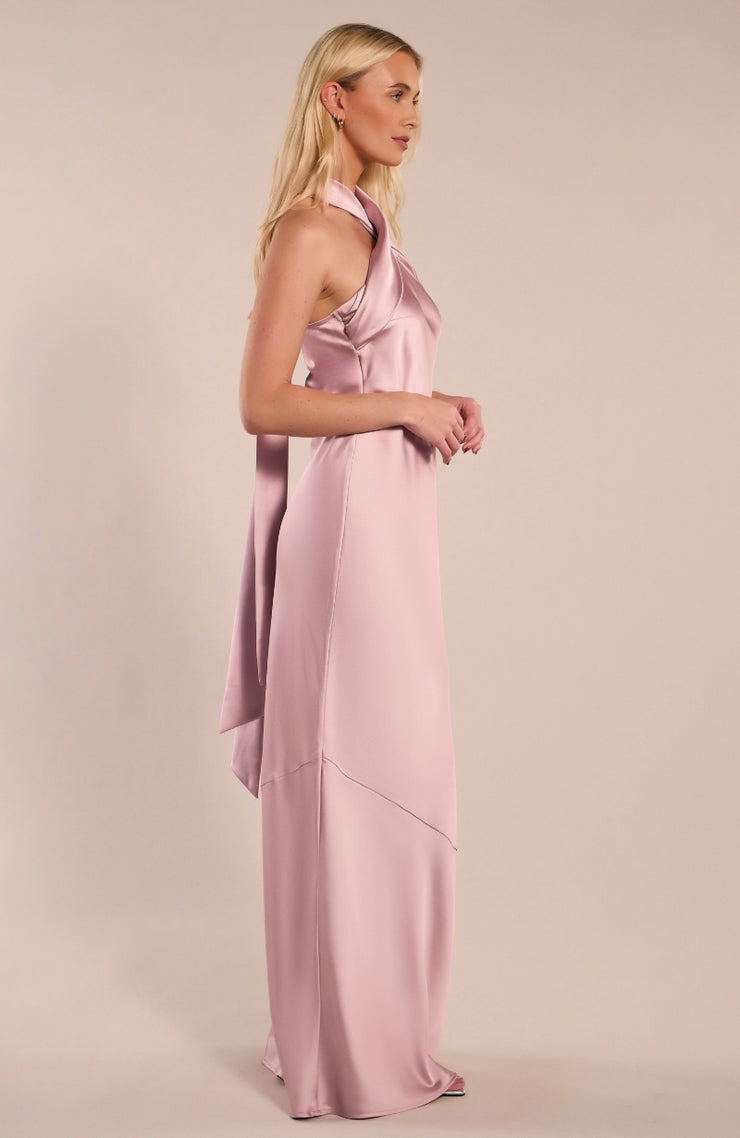 Woman wearing a pink satin gown against a beige background